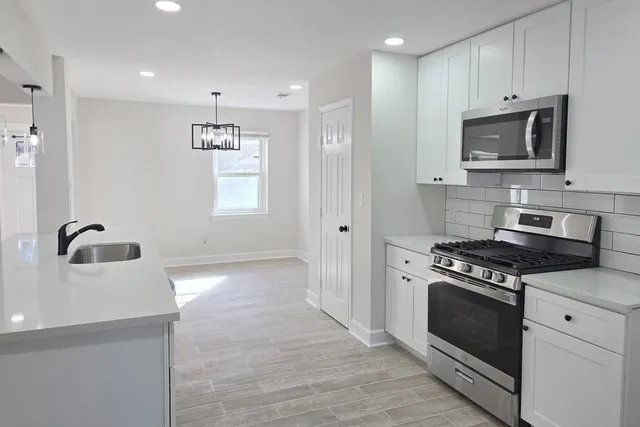 a kitchen with granite countertop a stove and a sink