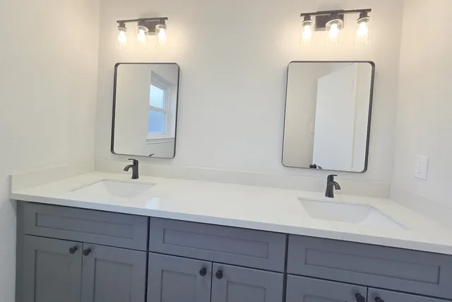 a bathroom with double vanity sinks and a mirror