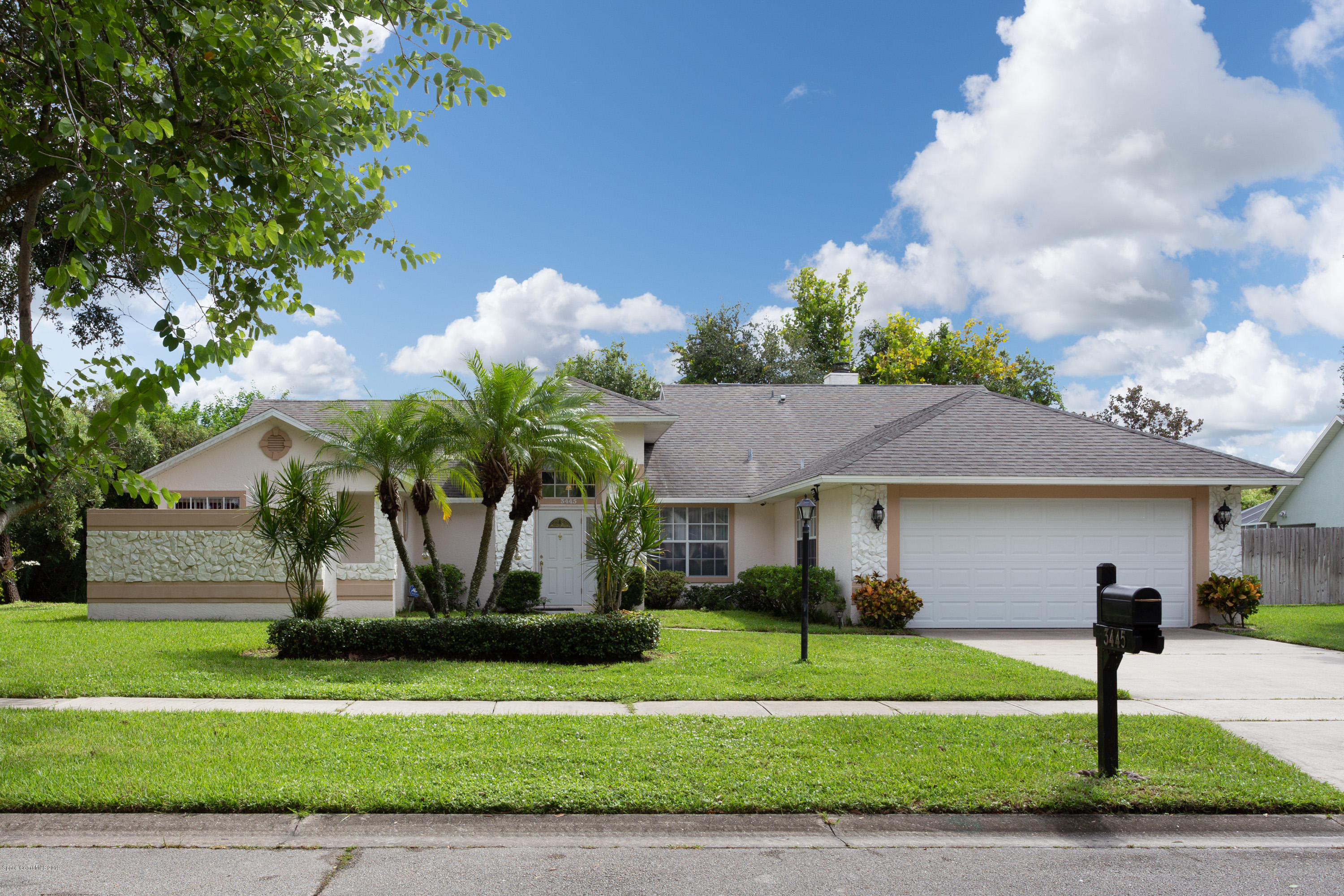 a front view of a house with a yard and potted plants