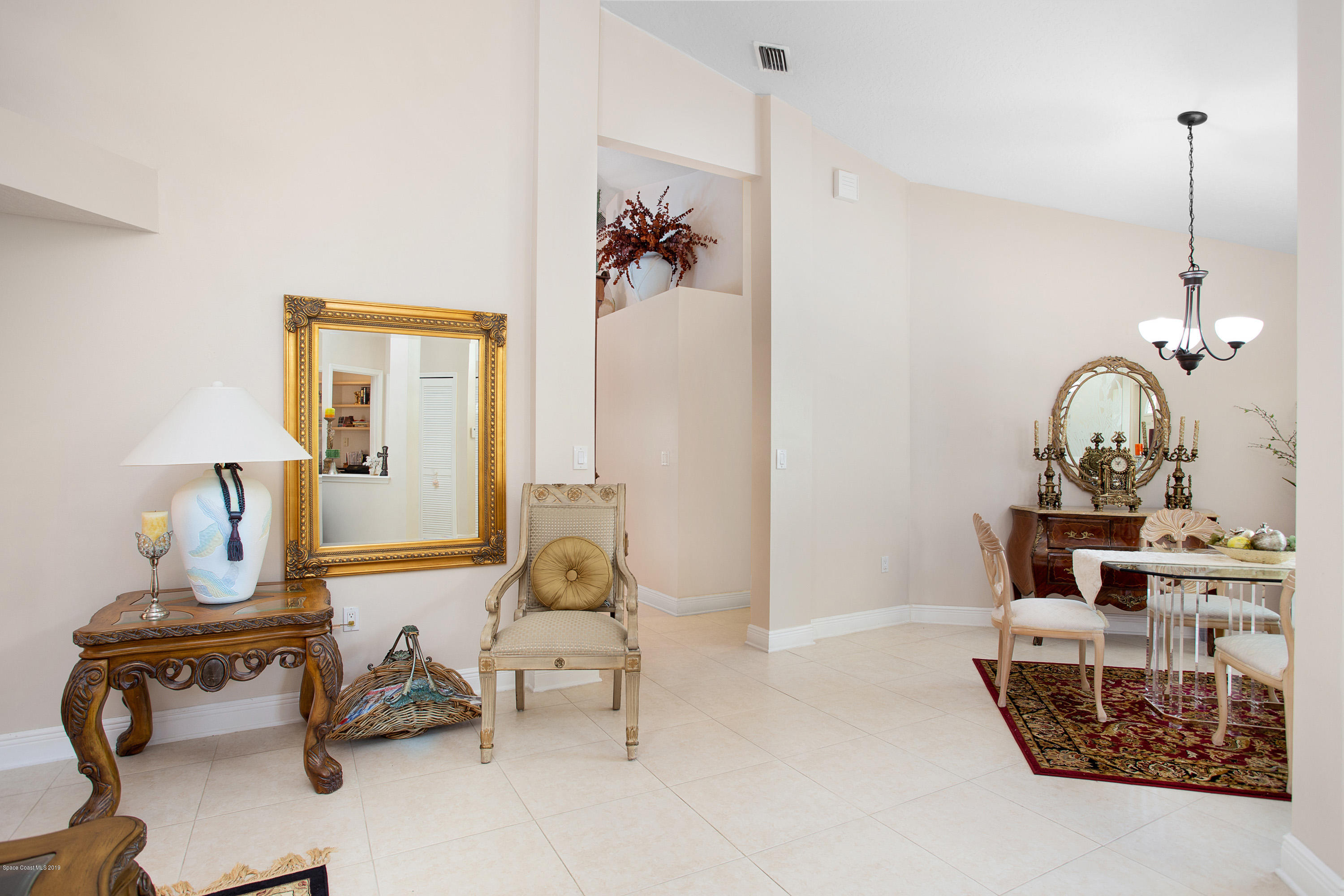 3445 Holly Springs Road Melbourne, FL 32934 - Photo 11 of 28 a living room with furniture and a mirror