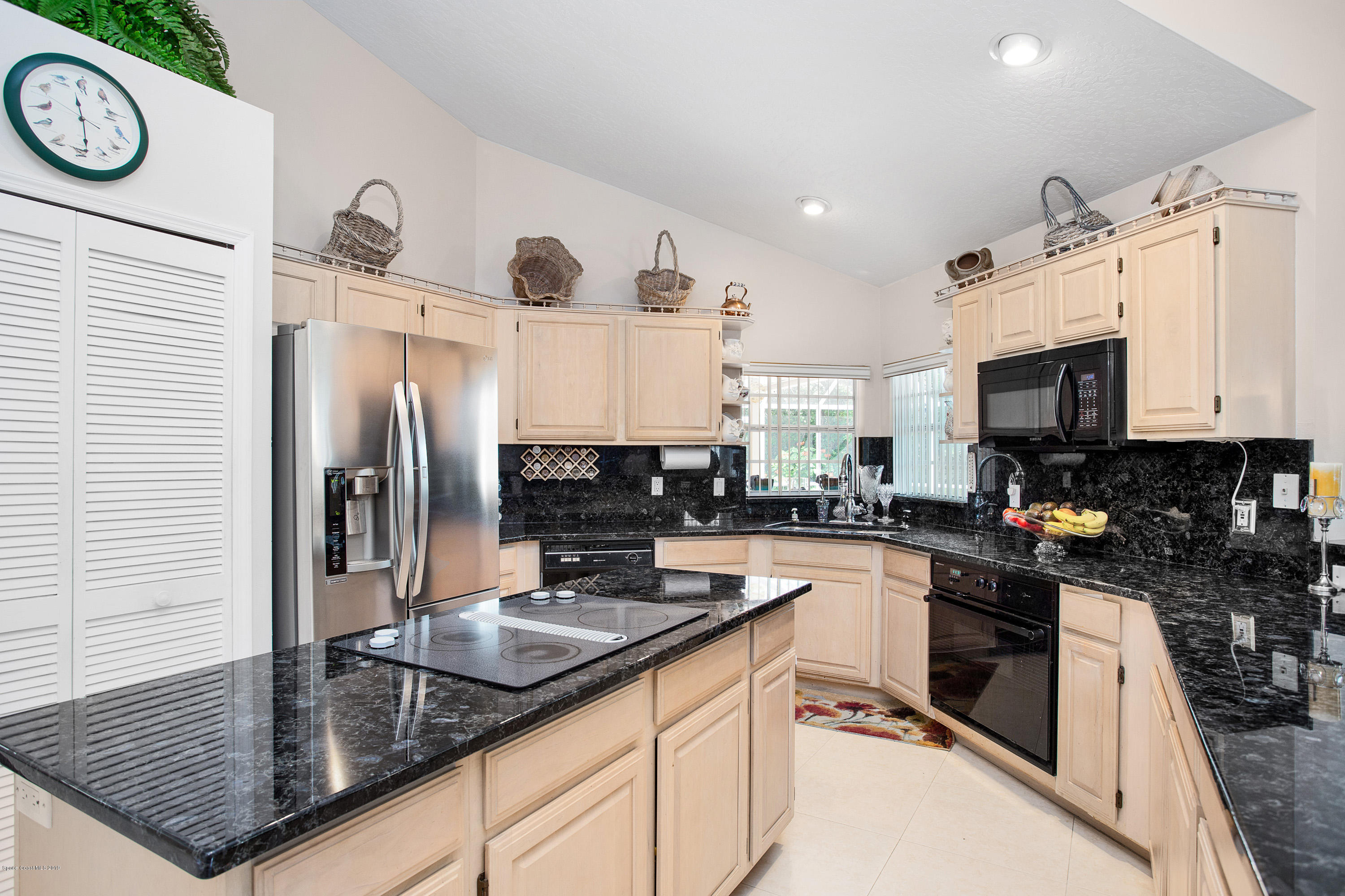 3445 Holly Springs Road Melbourne, FL 32934 - Photo 12 of 28 a kitchen with granite countertop a sink a stove and refrigerator