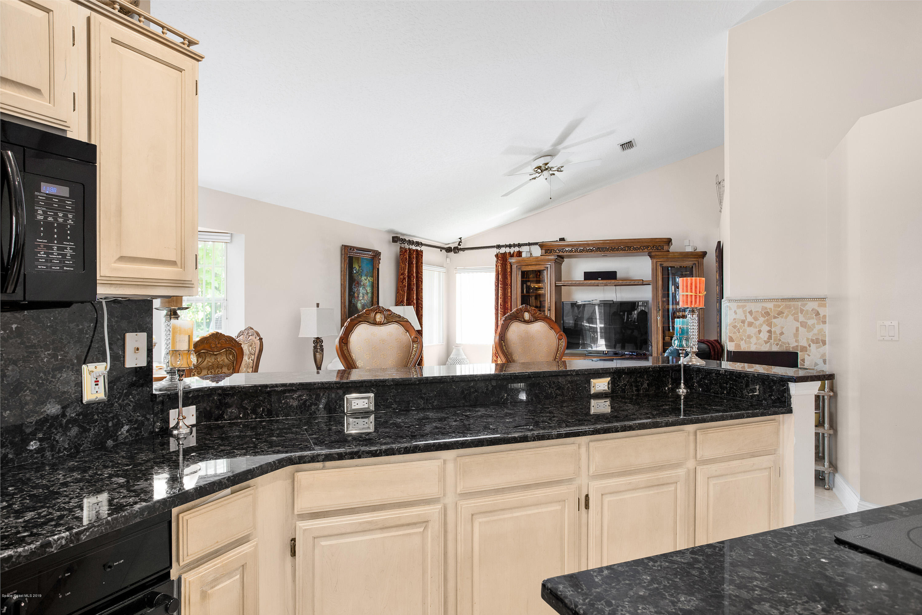 3445 Holly Springs Road Melbourne, FL 32934 - Photo 13 of 28 a kitchen with stainless steel appliances granite countertop a sink a stove and cabinets