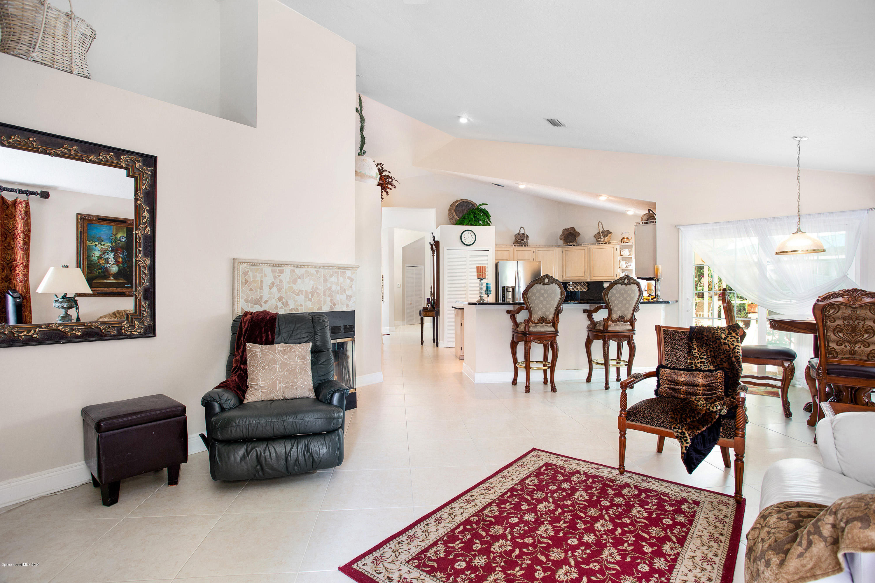 3445 Holly Springs Road Melbourne, FL 32934 - Photo 16 of 28 a living room with furniture and a fireplace