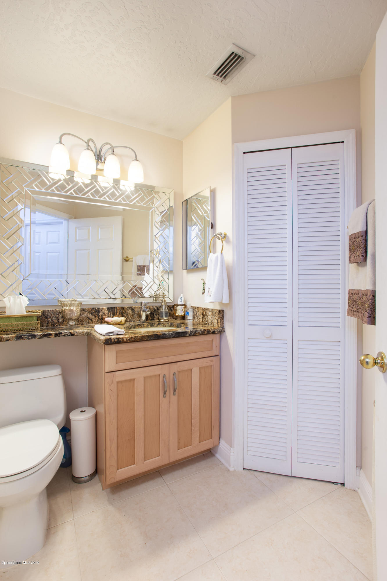3445 Holly Springs Road Melbourne, FL 32934 - Photo 22 of 28 a bathroom with a granite countertop sink and a mirror