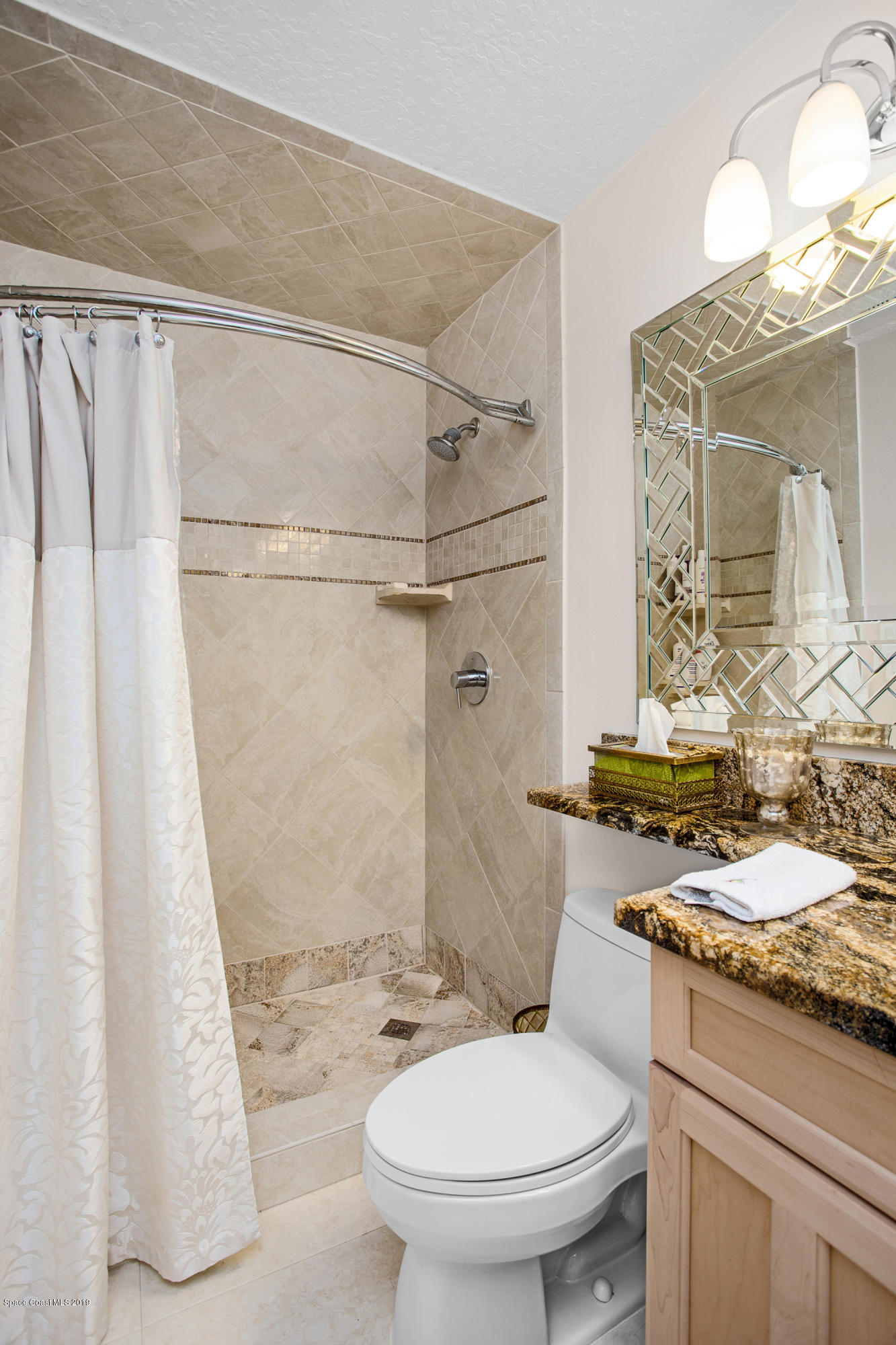 3445 Holly Springs Road Melbourne, FL 32934 - Photo 23 of 28 a bathroom with a granite countertop sink toilet and shower