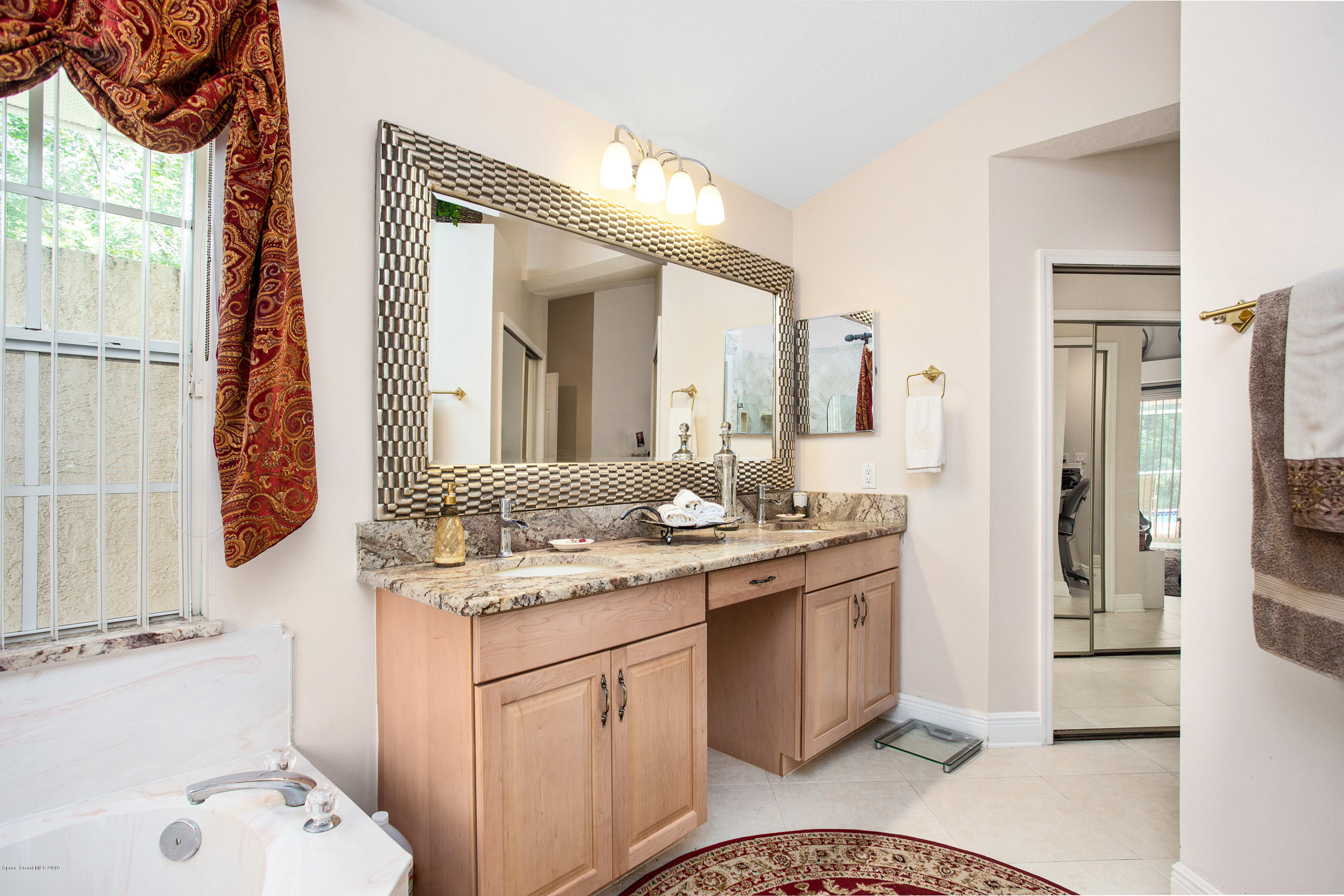 3445 Holly Springs Road Melbourne, FL 32934 - Photo 7 of 28 a bathroom with a sink and a mirror