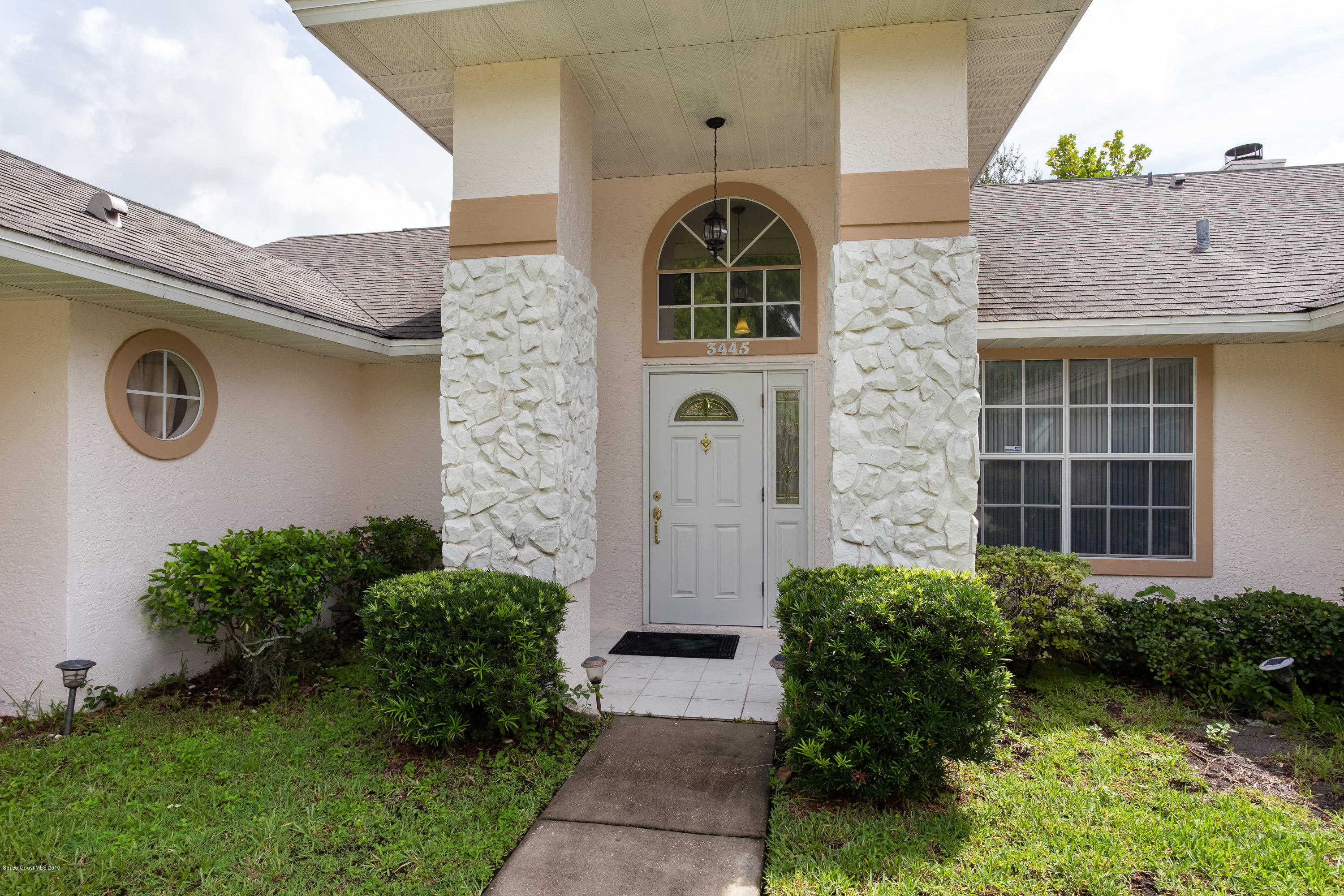 3445 Holly Springs Road Melbourne, FL 32934 - Photo 8 of 28 a front view of a house with garden