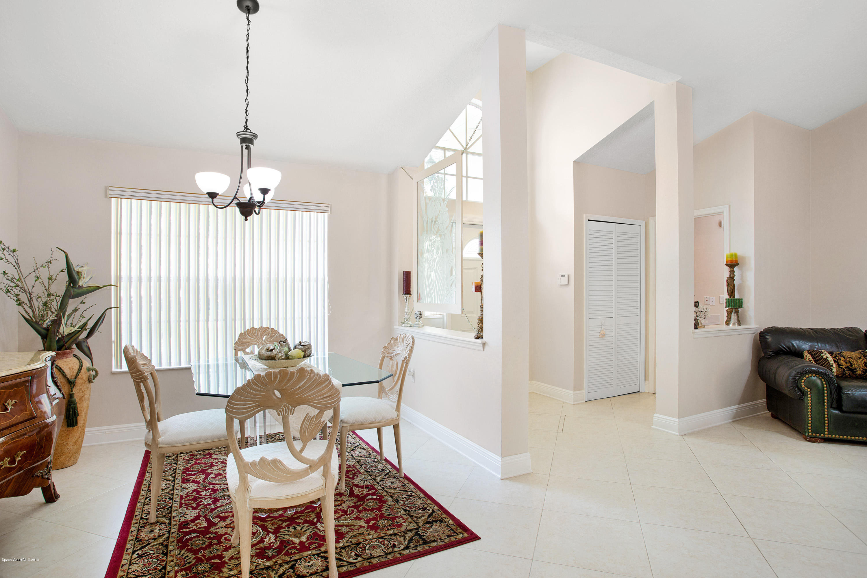 3445 Holly Springs Road Melbourne, FL 32934 - Photo 10 of 28 a living room with furniture and a chandelier