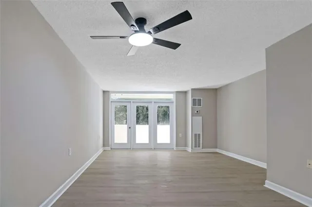 an empty room with wooden floor and windows