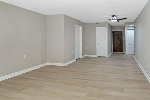 a view of a hallway with wooden floor and closet