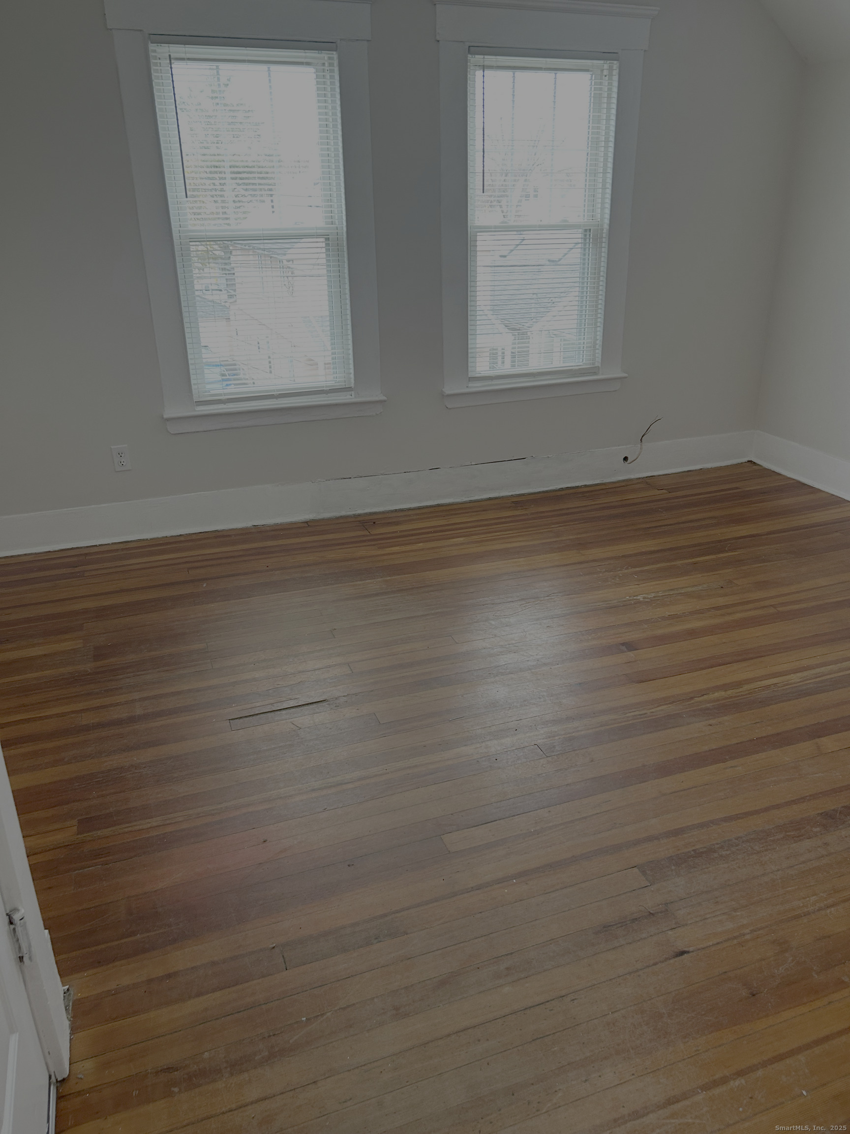 64 Lexington Street Hamden, CT 06514 - Photo 3 of 6 an empty room with wooden floor and windows