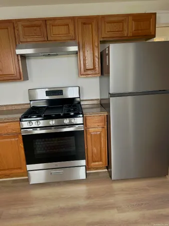 a kitchen with wooden cabinets and a stove top oven