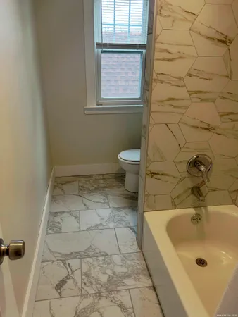 a bathroom with a sink a toilet and window