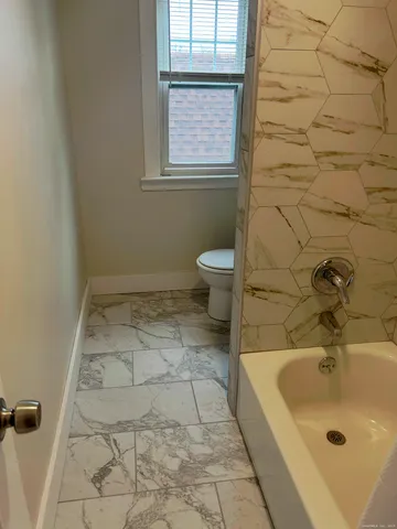a bathroom with a sink a toilet and window