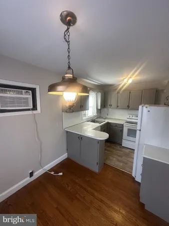 a kitchen with a sink cabinets and wooden floor