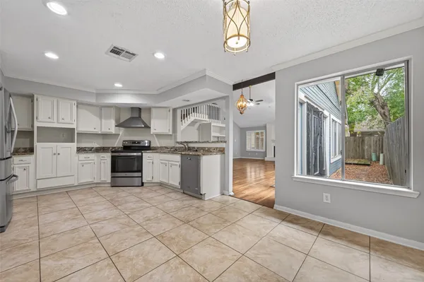 a kitchen with stainless steel appliances granite countertop a refrigerator and a stove top oven