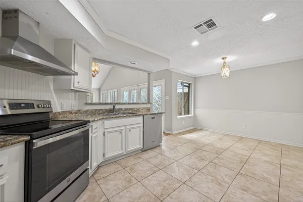 a kitchen with granite countertop a stove sink and cabinets