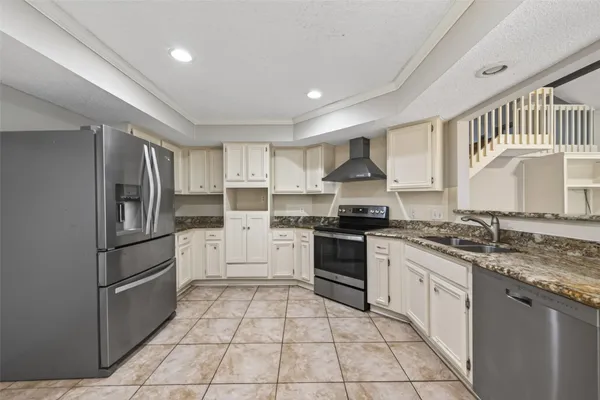 a kitchen with stainless steel appliances granite countertop a stove a sink and a refrigerator