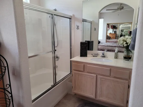 a bathroom with a sink a mirror a vanity and shower