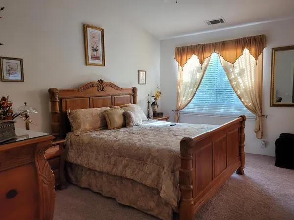 a bed sitting in a bedroom next to a window