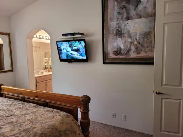 a bedroom with a bed and a painting on the wall