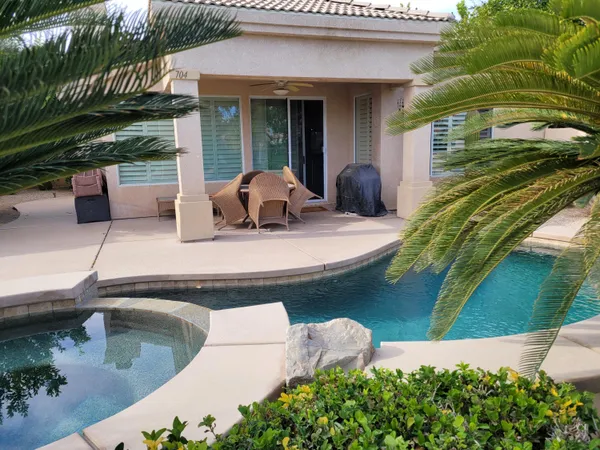 a view of a house with pool and sitting area