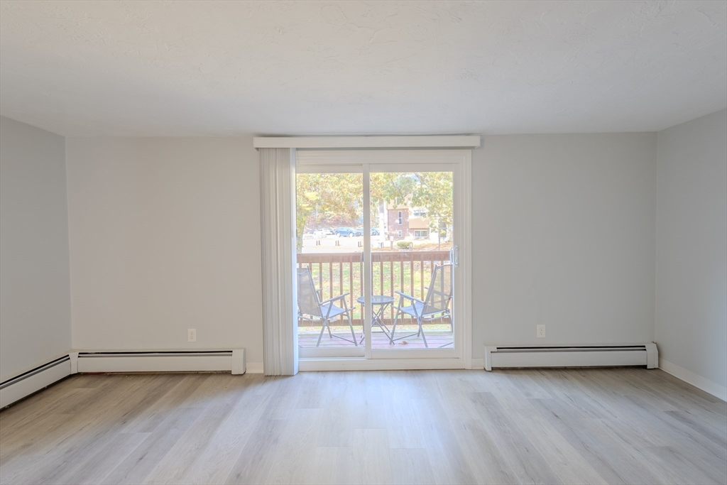 5 Tideview Path, Unit 4 Plymouth, MA 02360 - Photo 12 of 16 an empty room with wooden floor and windows