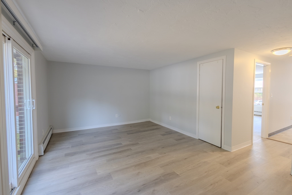 5 Tideview Path, Unit 4 Plymouth, MA 02360 - Photo 13 of 16 an empty room with wooden floor and windows