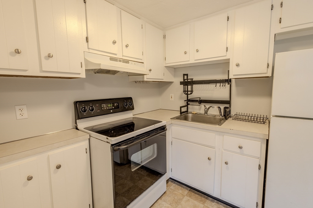 5 Tideview Path, Unit 4 Plymouth, MA 02360 - Photo 15 of 16 a kitchen with granite countertop white cabinets and white appliances