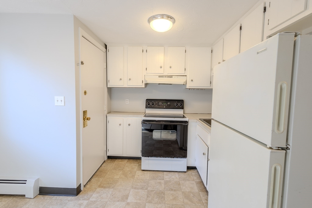 5 Tideview Path, Unit 4 Plymouth, MA 02360 - Photo 4 of 16 a kitchen with a refrigerator stove and white cabinets