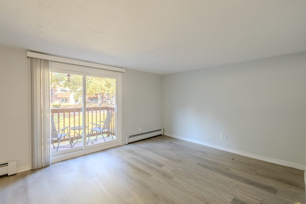 5 Tideview Path, Unit 4 Plymouth, MA 02360 - Photo 9 of 16 an empty room with wooden floor and windows