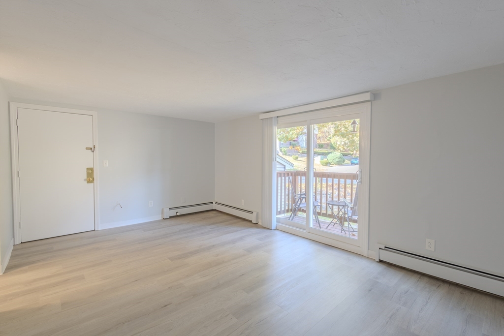 5 Tideview Path, Unit 4 Plymouth, MA 02360 - Photo 10 of 16 an empty room with wooden floor and windows