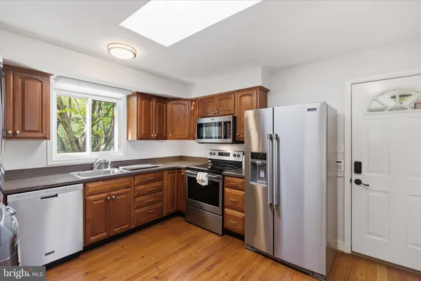 a kitchen with stainless steel appliances granite countertop a refrigerator and wooden cabinets
