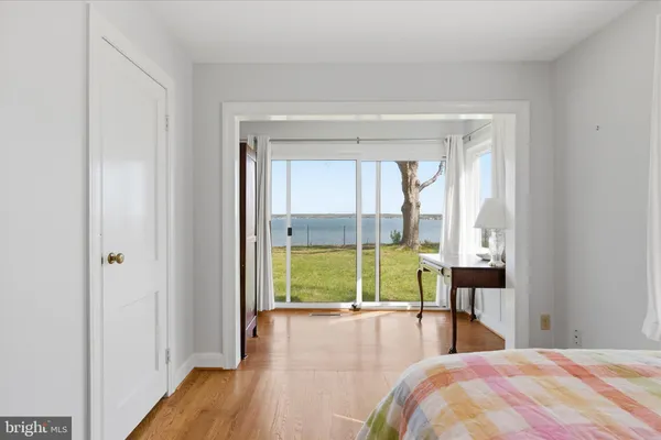 a bedroom with a bed and large windows
