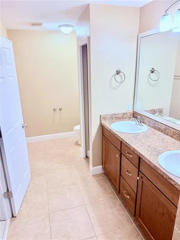 a spacious bathroom with a granite countertop sink and a mirror