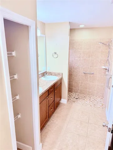 a spacious bathroom with a double vanity sink a mirror and a shower
