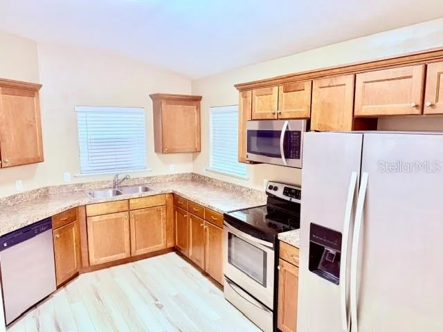 a kitchen with stainless steel appliances granite countertop a stove a sink and a refrigerator
