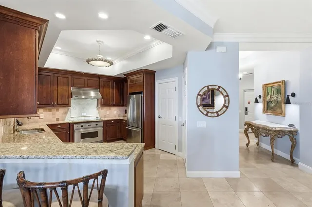 a kitchen with stainless steel appliances granite countertop a refrigerator and a stove top oven