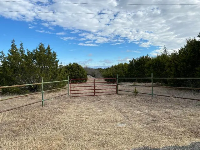 a view of a yard with wooden fence