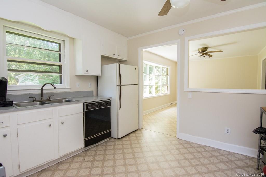 7424 Watercrest Road, Unit 14 Charlotte, NC 28210 - Photo 7 of 21 a kitchen with granite countertop a refrigerator a sink a stove and white cabinets