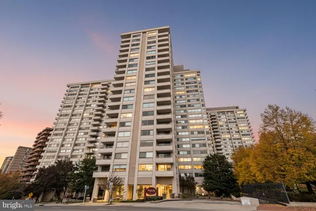 a living room with furniture a large window and potted plant