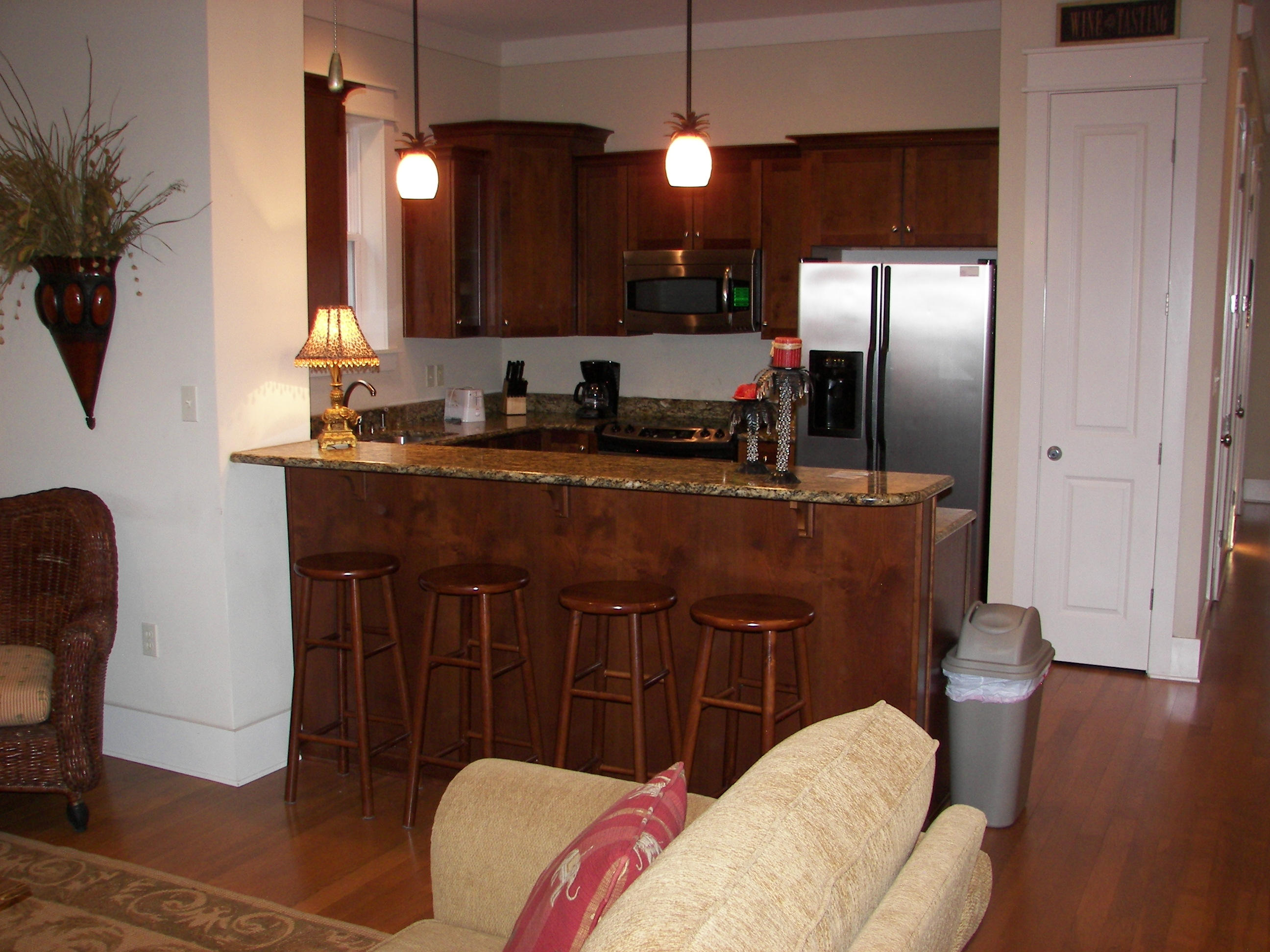 69 Lifeguard Loop West Inlet Beach, FL 32461 - Photo 11 of 34 a kitchen with stainless steel appliances granite countertop a sink a stove a refrigerator a dining table and chairs with wooden floor