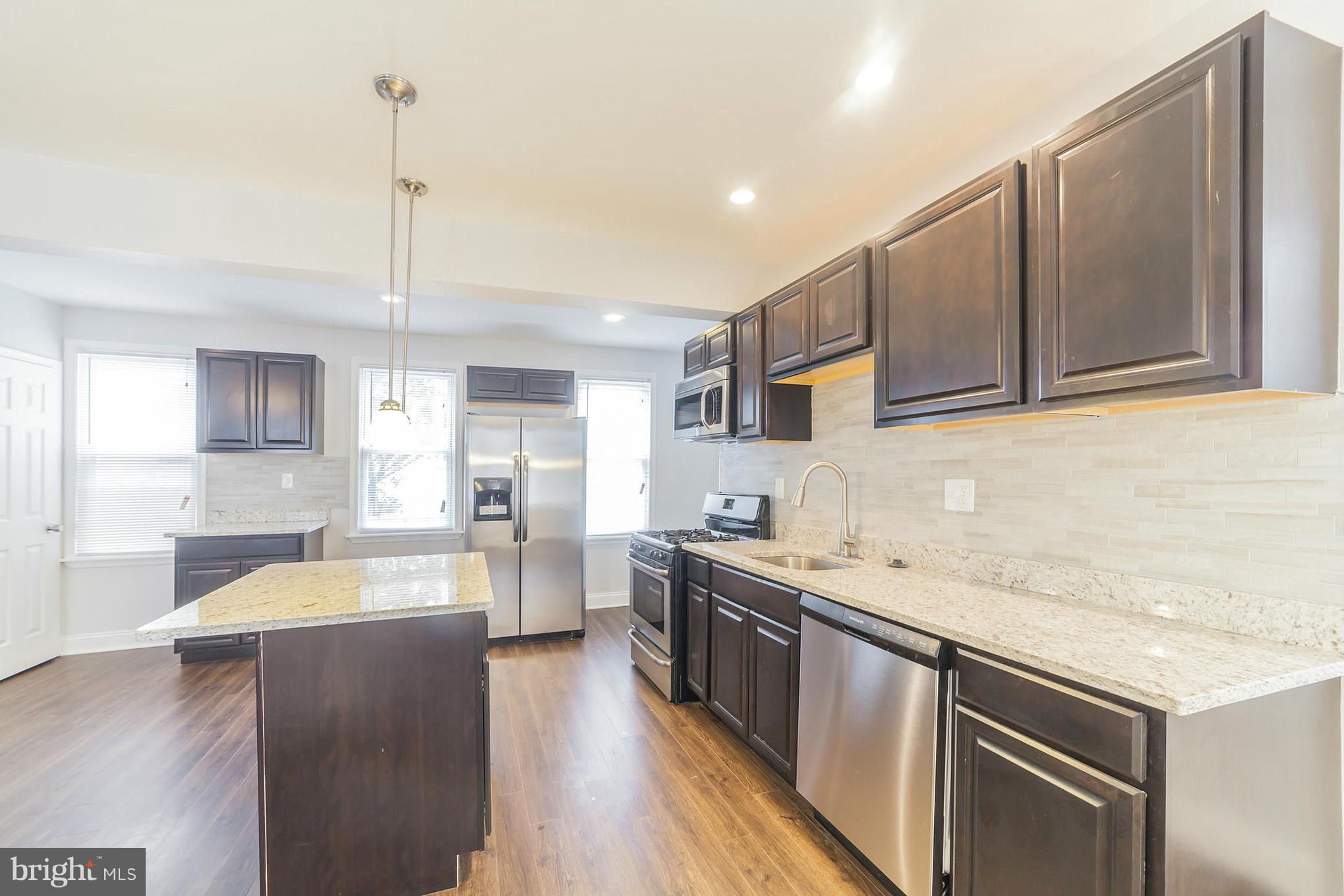 5502 Tramore Road Baltimore, MD 21214 - Photo 12 of 30 a kitchen with a sink stove and cabinets