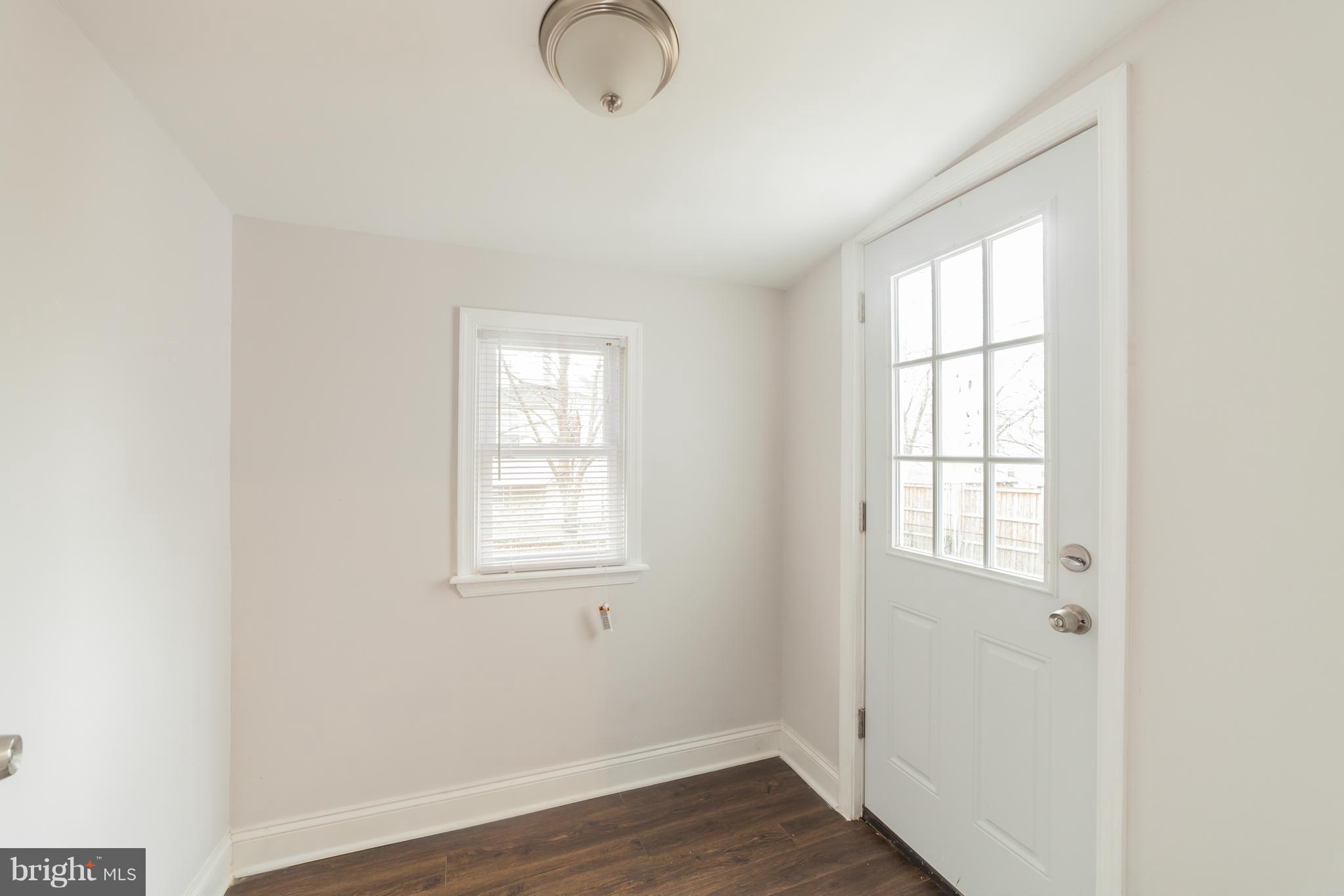 5502 Tramore Road Baltimore, MD 21214 - Photo 30 of 30 an empty room with wooden floor and windows