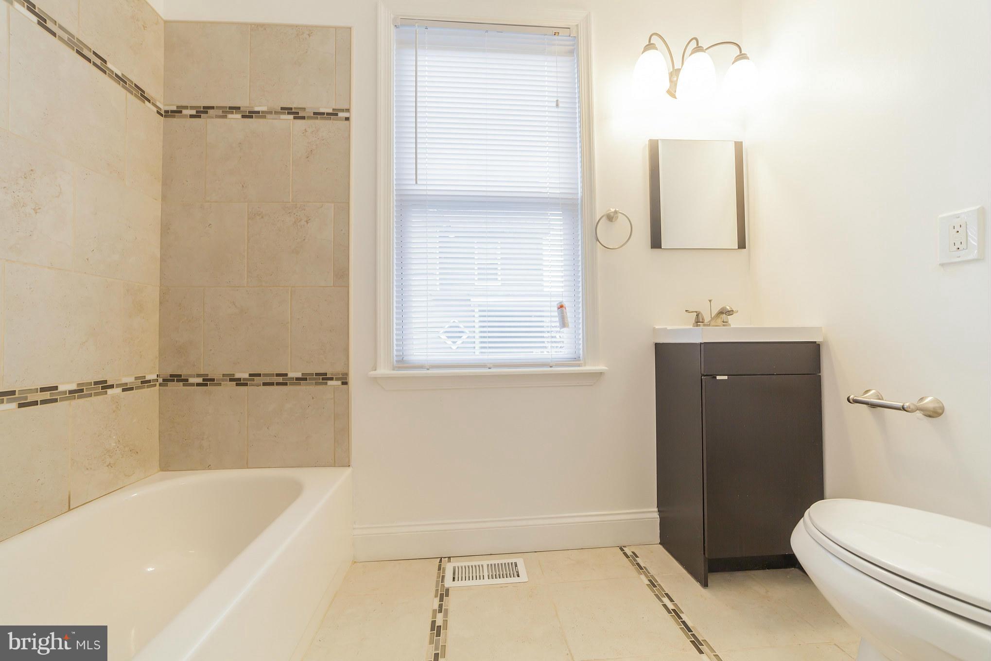 5502 Tramore Road Baltimore, MD 21214 - Photo 8 of 30 a bathroom with a sink toilet and shower