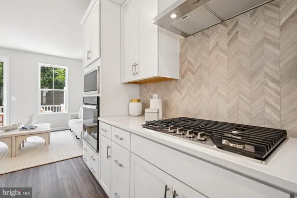 a kitchen with stainless steel appliances granite countertop a stove a sink dishwasher and cabinets with wooden floor