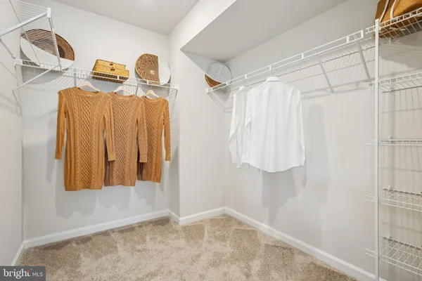 a view of walk in closet with clothes and shoes