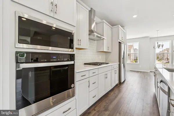 a kitchen with stainless steel appliances kitchen island granite countertop a stove and a microwave