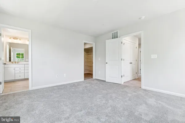 an empty room with windows and a bathroom