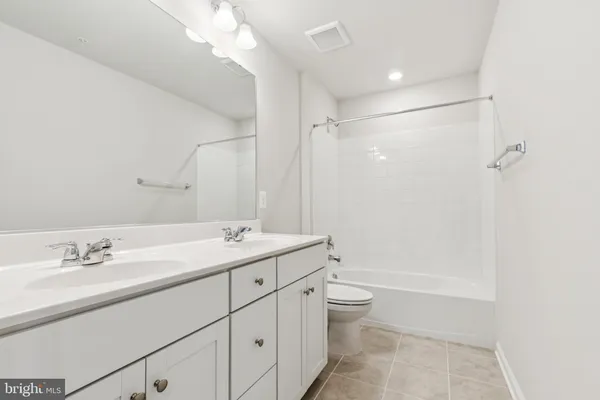 a bathroom with a double vanity sink toilet and shower